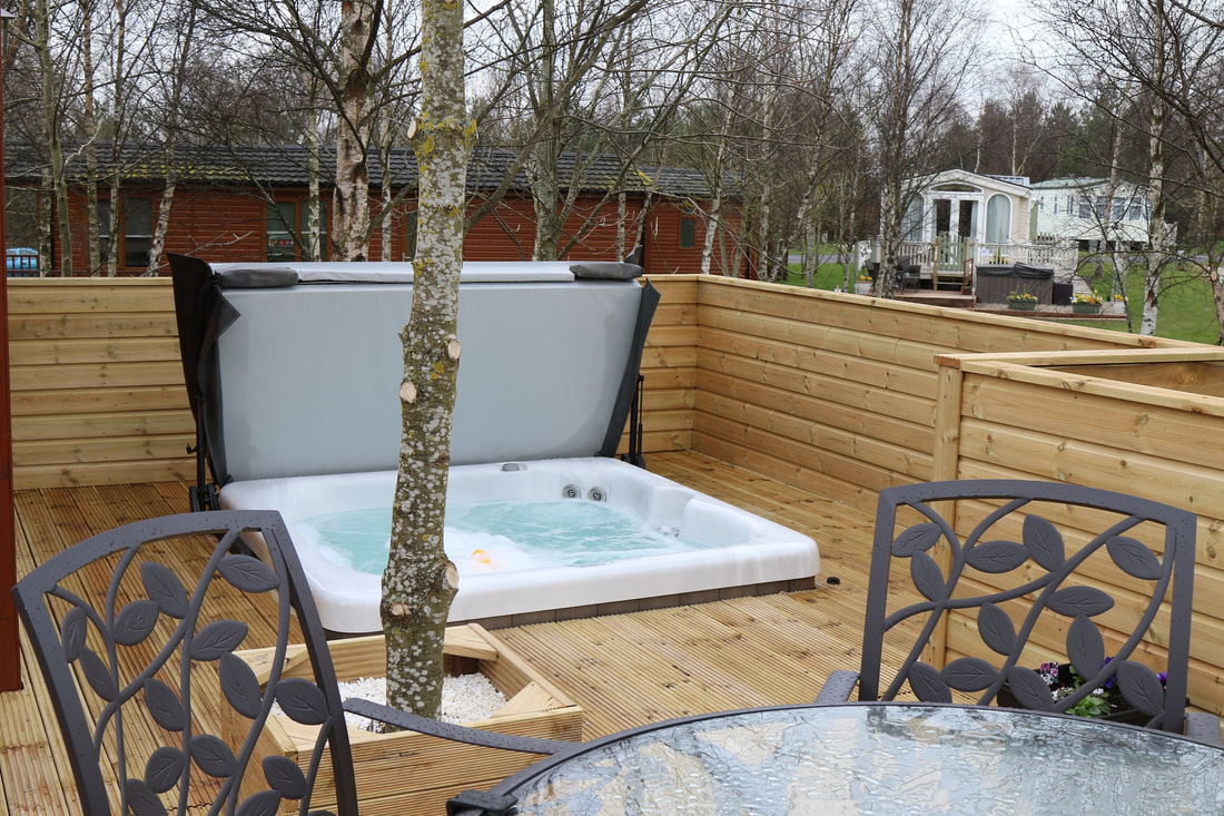 North East lodge decking with hot tub, timber balustrade and outdoor seating